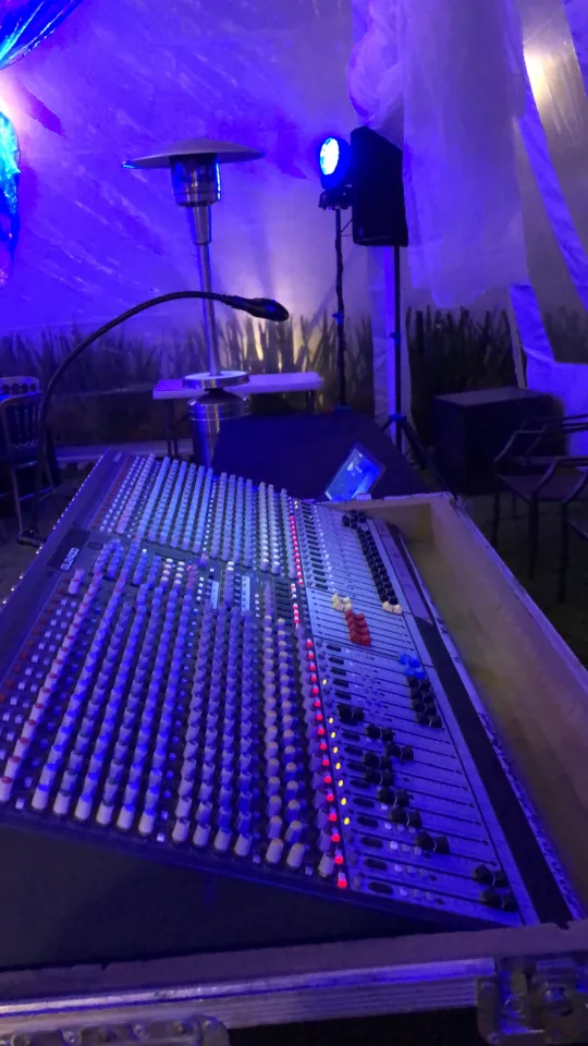 Consola de mezcla y equipo de operación bajo iluminación azul.