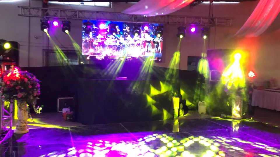 Pantalla LED sobre una cabina, con luces amarillas y proyecciones en la pista.
