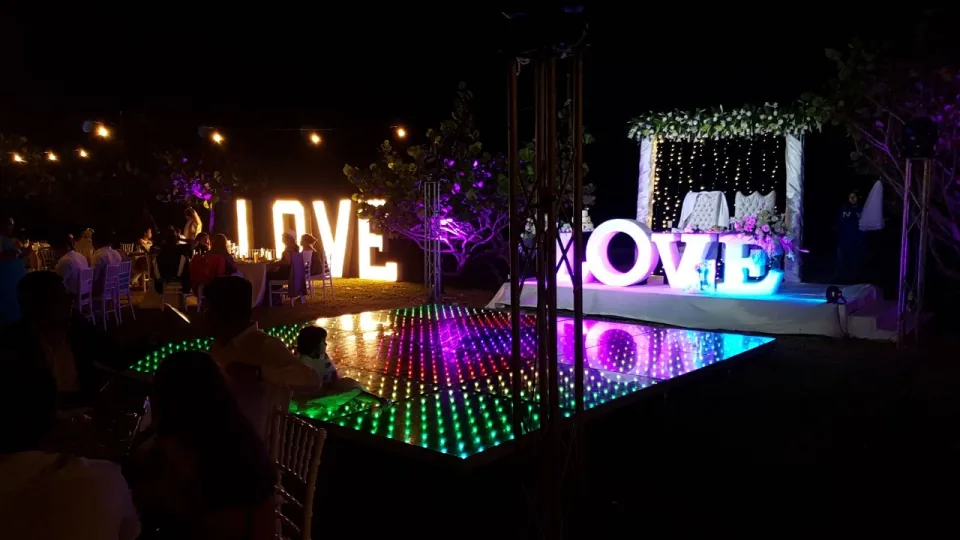 Pista LED encendida de noche, rodeada por letras luminosas que forman LOVE.
