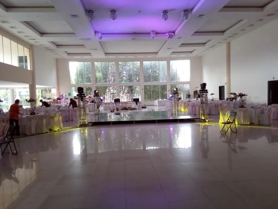 Salón preparado con mesas, sillas y una pista de baile al centro.